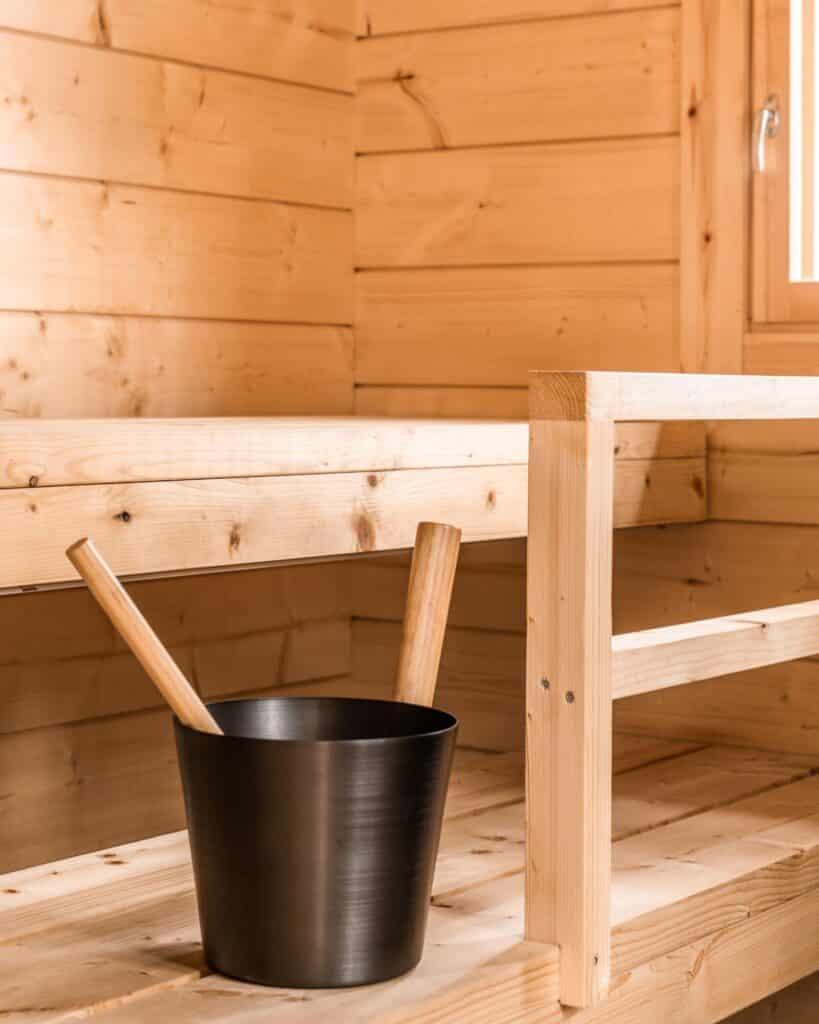 Tyylikäs hirsisauna - Pihasauna 13 vaaleat lauteet ja löylykiulu