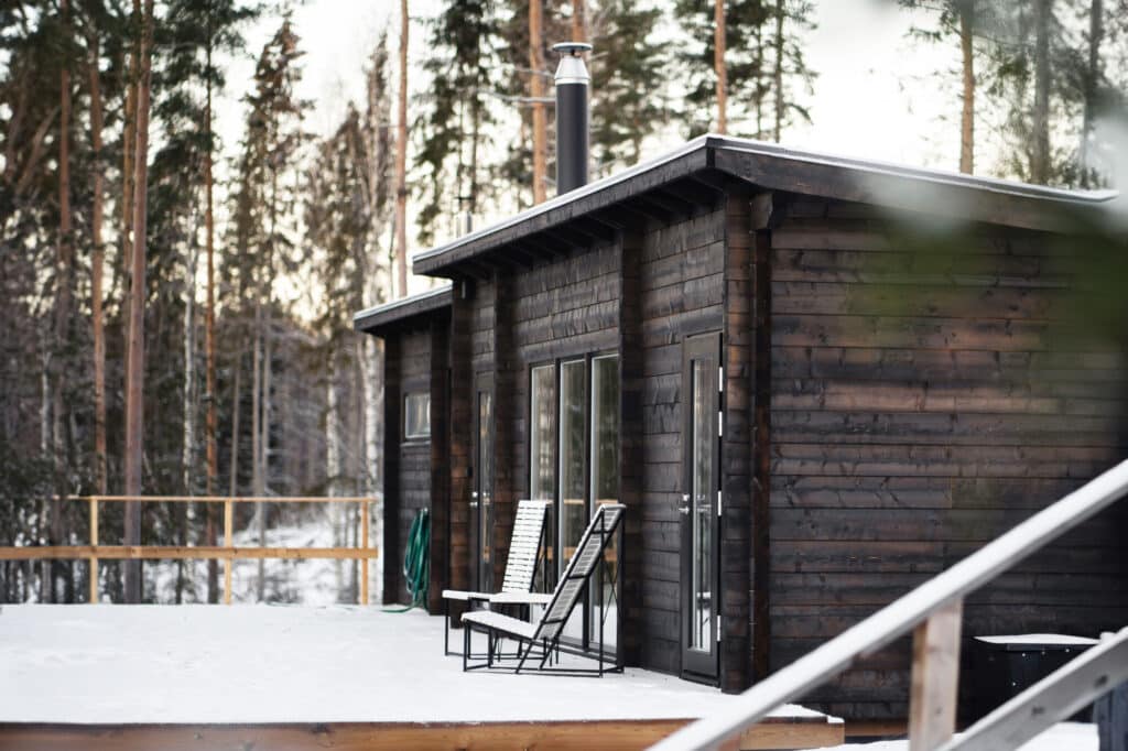 Tumma Ehta-villa pulpettikatolla lumisella terassilla männikössä
