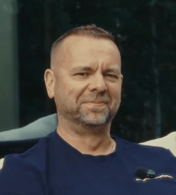 Keski-ikäinen, lyhythiuksinen ja parrakas Åke Nublom, istuu ulkona Ehtan 2025 talvikampanjan aikana ja katsoo kameraan hieman hymyillen.